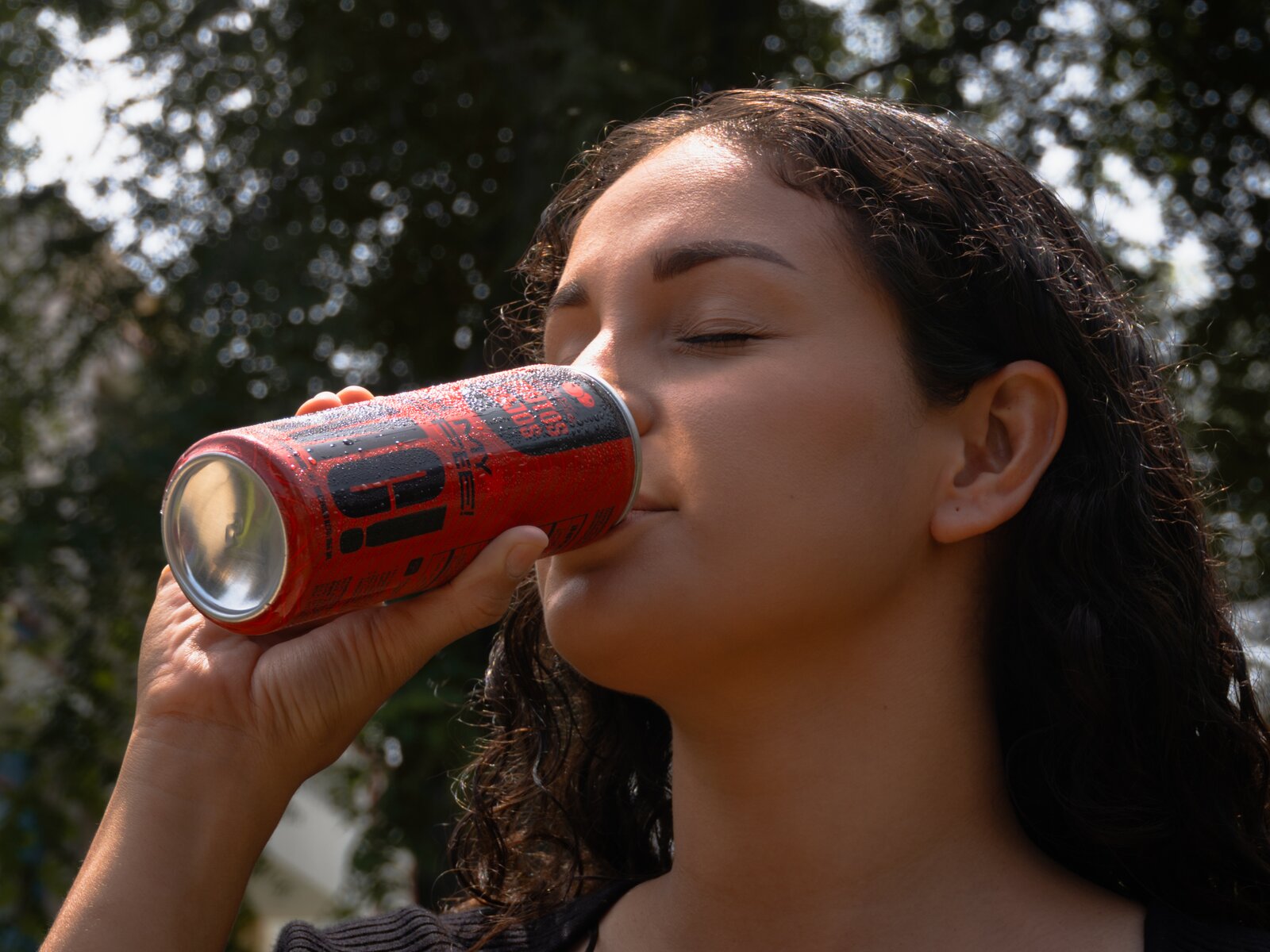 Persona sosteniendo una lata de OMC! Frutos Rojos al aire libre