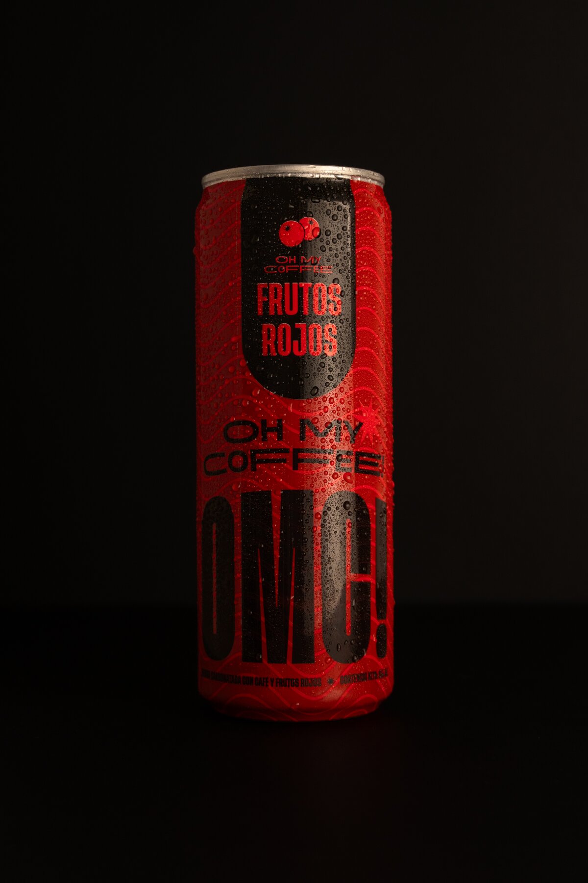 Lata OMC! Frutos Rojos sobre superficie oscura con condensación